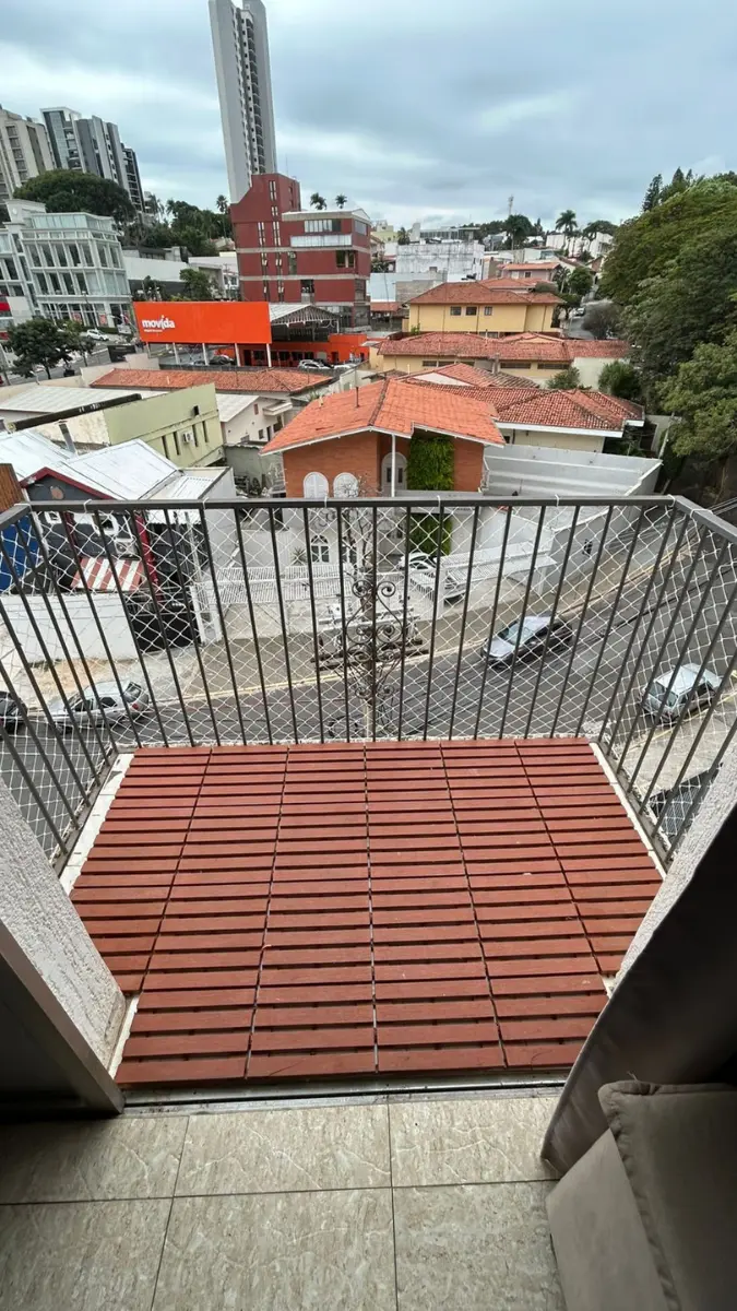 Sacada residencial com deck de ripas de madeira fechada com rede de proteção tensionada.